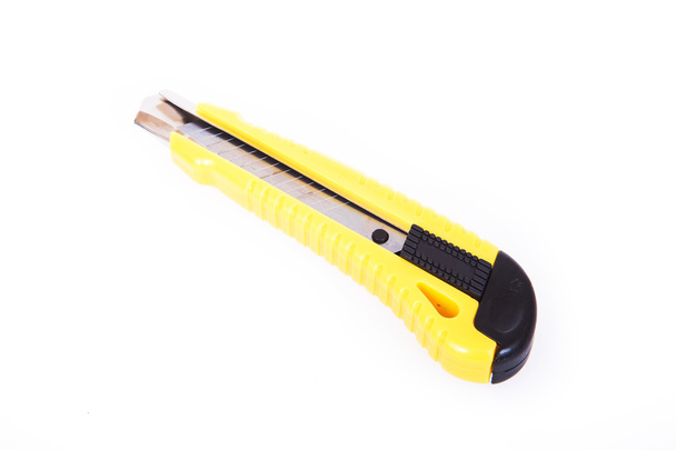 Das gelbe Schreibwarenmesser isoliert auf weißem Hintergrund - Foto, Bild