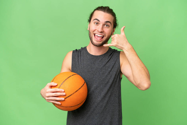 Joven jugador de baloncesto hombre sobre fondo aislado haciendo gesto de teléfono. Llámame señal de vuelta - Foto, imagen