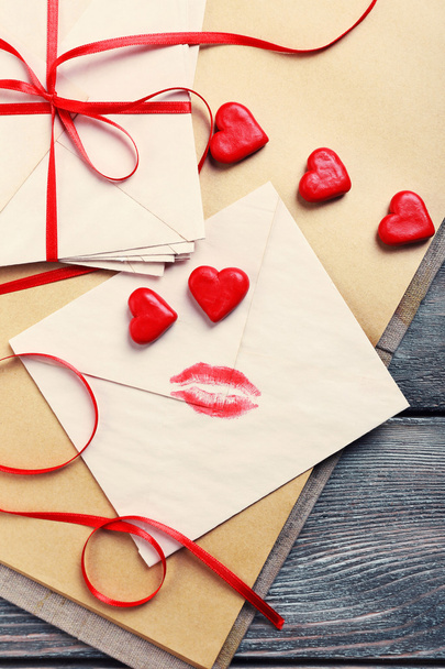 Love letters with red ribbon on wooden background - 写真・画像
