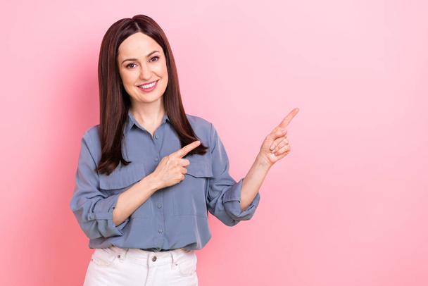 Photo promoter young cheerful smiling businesswoman directing fingers empty space open new main office building isolated on pink color background. - Foto, immagini