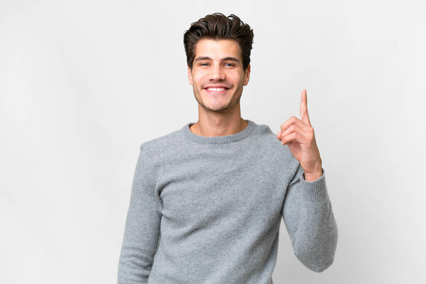 Young handsome caucasian man over isolated white background pointing with the index finger a great idea - 写真・画像