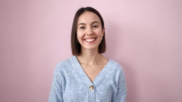 Young beautiful hispanic woman smiling confident doing kissing over isolated pink background - Footage, Video