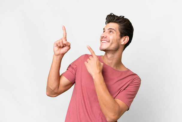 Giovane uomo caucasico bello su sfondo bianco isolato che punta con il dito indice una grande idea - Foto, immagini