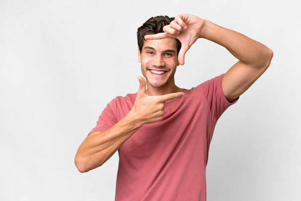 Young handsome caucasian man over isolated white background focusing face. Framing symbol - Foto, Imagen