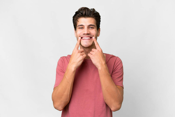 Young handsome caucasian man over isolated white background smiling with a happy and pleasant expression - Foto, imagen