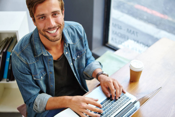 Хес на кавовому дзвоні. Портрет красивого молодого чоловіка, який використовує свій ноутбук у кав'ярні
 - Фото, зображення