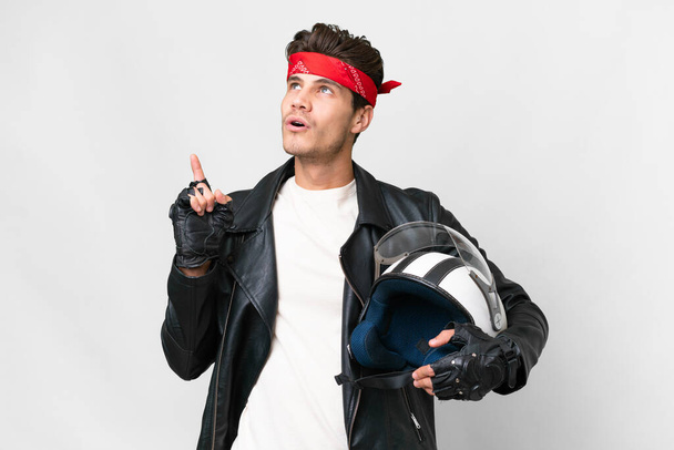 Young caucasian man with a motorcycle helmet over isolated white background thinking an idea pointing the finger up - Foto, immagini