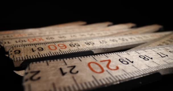 数字と線のあるヴィンテージの定規は、測定の準備ができて暗いテーブルの上にあります。長さを測定するための木材で作られたセンチメートル装置 - 映像、動画