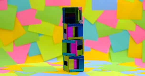 creatividad para hacer grapas en forma de caja sobre una mesa giratoria con un fondo de notas adhesivas de papel multicolor, 4K DCI - Metraje, vídeo