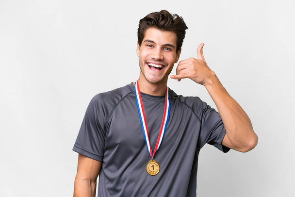 Young caucasian man with medals over isolated white background making phone gesture. Call me back sign - Photo, Image