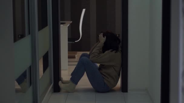 Sfrustrowana osoba siedząca na podłodze cierpiąca na ból emocjonalny. Zmartwiona młoda kobieta w kryzysie - Materiał filmowy, wideo