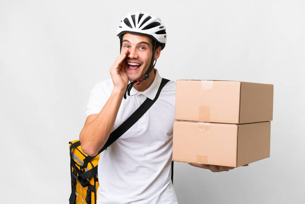 Entrega homem vestindo uma bicicleta capacete sobre fundo branco isolado gritando com a boca aberta - Foto, Imagem