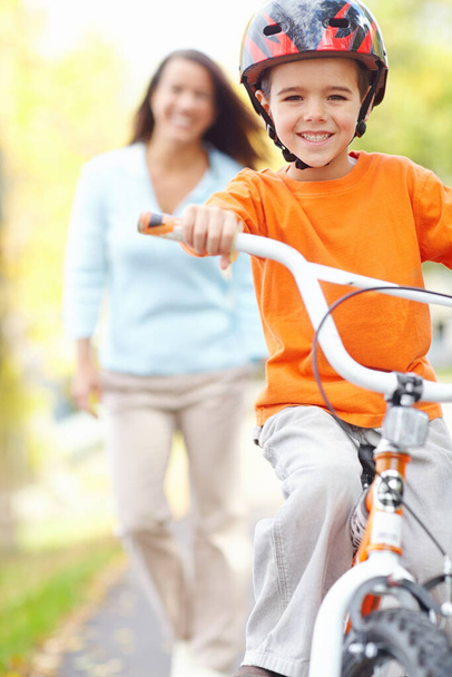 Katso minua, äiti. äiti katselee poikansa ratsastaa hänen polkupyörä - Valokuva, kuva