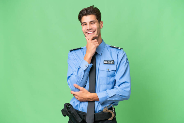 Joven policía sobre fondo aislado sonriendo - Foto, Imagen