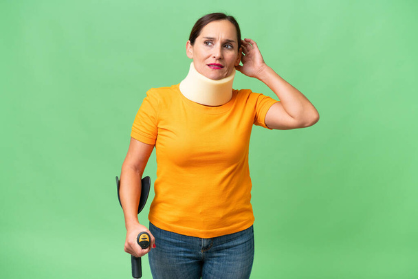 Middle-aged caucasian woman wearing neck brace over isolated background having doubts - Foto, Bild
