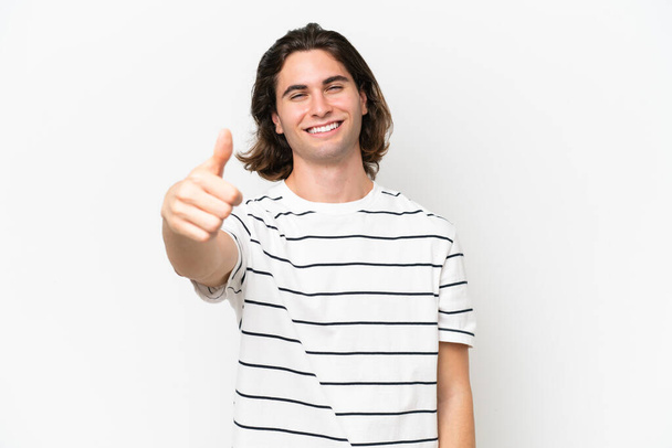 Young handsome man isolated on white background with thumbs up because something good has happened - Photo, Image