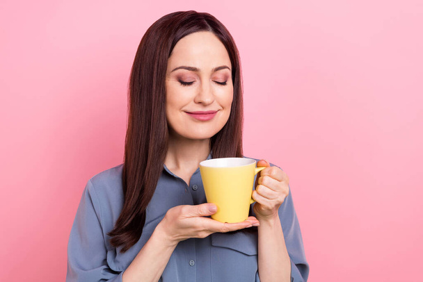 Photo of relaxed pretty young lady wear blue formal shirt hold yellow mug fresh coffee latte macchiato smell aroma isolated on pink color background. - Zdjęcie, obraz