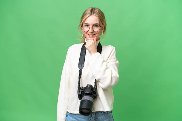 Młoda fotograf Angielska kobieta na odosobnionym tle z okularami i uśmiechem - Zdjęcie, obraz