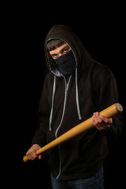 Teenage boy with a black mask a hoodie and a  baseball bat - Foto, Bild