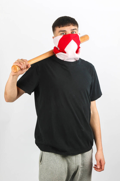 A teenage boy with a basball bat wearing an England Flag mask against a white background - Photo, image