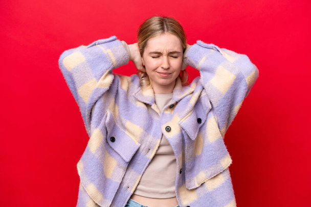Young English woman isolated on red background frustrated and covering ears - Foto, afbeelding