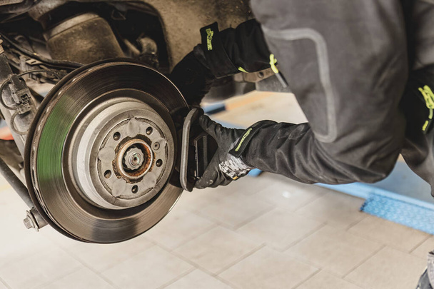 Skilled mechanic expertly replaces brake pads on a car with precision and care. - Foto, immagini
