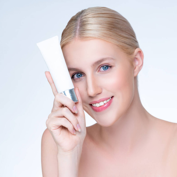 Closeup personable beautiful perfect natural skin woman hold mockup tube moisturizer cream for skincare treatment product advertising expressive facial and gesture expression in isolated background. - Fotografie, Obrázek