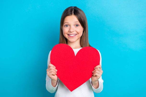Photo of good mood nice girl with long hairstyle wear white long sleeve hold large figure paper heart isolated on blue color background. - 写真・画像