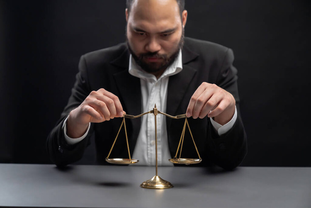 Focus scale balance with blur lawyer sitting at his desk with worried and exhausted expression, feeling weight of pressure and stress of making hard decision on verdict. equility - Foto, imagen