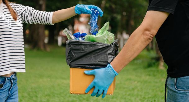  mains tenant les ordures mises dans un sac de recyclage. Nettoyage, pollution, écologie et concept plastique - Photo, image