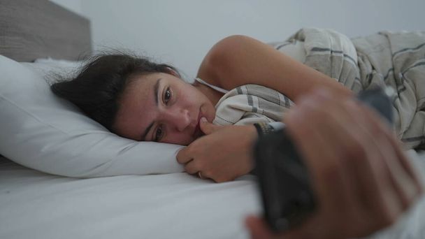 Woman watching media entertainment on phone consuming content online while laid in bed in the morning. Person addicted to technology - Фото, зображення