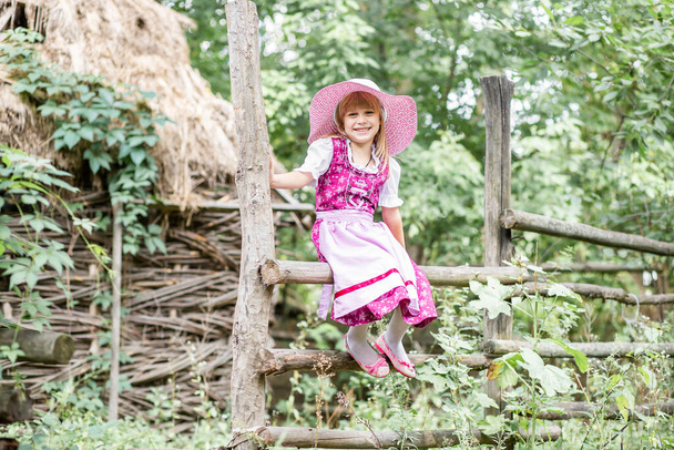 Красива маленька щаслива дівчинка в сукні і з букетом жовтих квітів на природі в селі. Дитина на відкритому повітрі. Дівчина на прогулянці в парку
. - Фото, зображення
