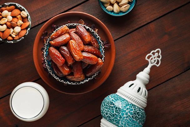 Ramadan Kareem and iftar muslim food. Pitted dates, nuts and milk on wooden boards. Traditional iftar food - Foto, Imagem