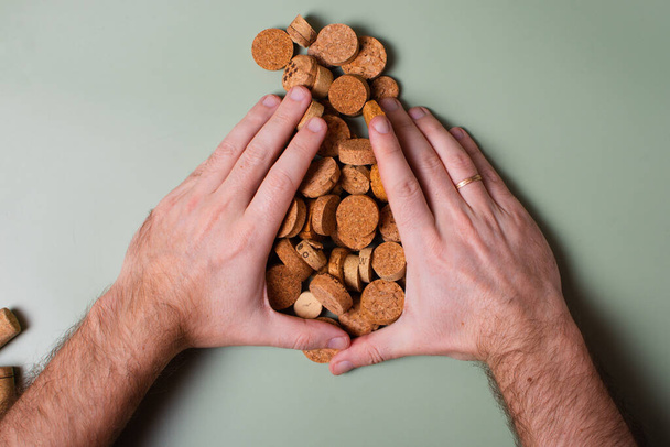 A man's hand holds cut corks and cuts them. Preservation of the planet's ecology. Raw materials for reuse. Environmental protection. - Photo, Image
