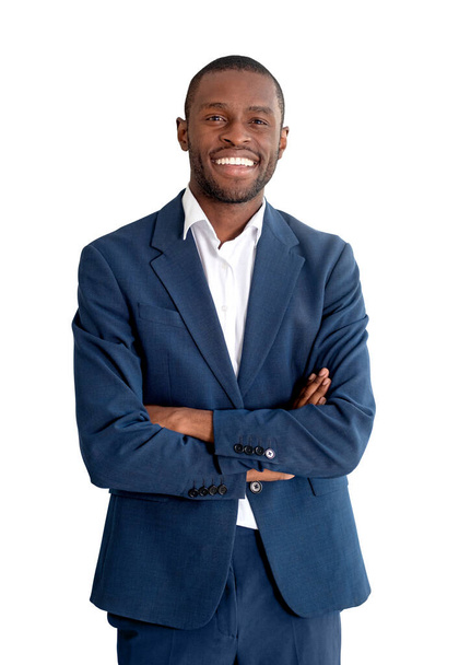 African businessman smiling in blue formal suit, looking at the camera, arms crossed, isolated over white background. Concept of business success and development - Fotografie, Obrázek
