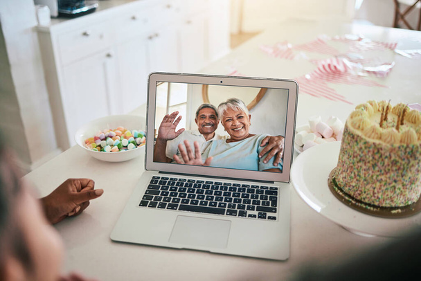 Video call, laptop and family with birthday cake, wave hello and virtual celebration, party and happy child talk at home. Biracial grandparents or people celebrate on computer screen for online chat. - 写真・画像