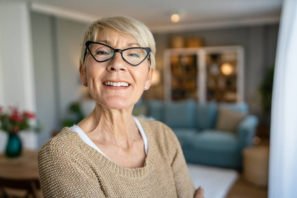 Close up portrait of one senior woman with short hair happy smile positive emotion copy space standing at home indoor wear eyeglasses - Foto, Imagem
