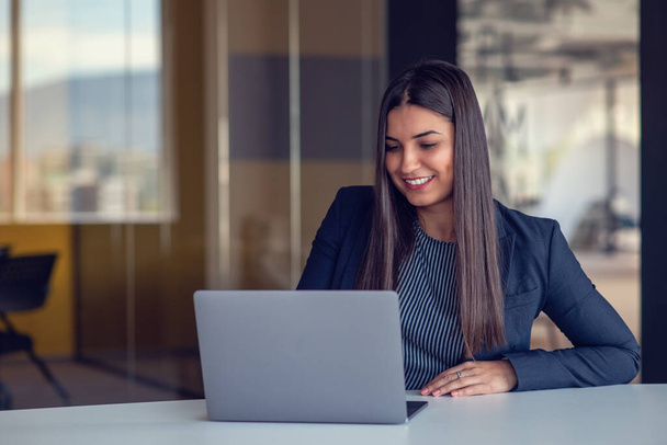 Portrait of beautiful businesswoman working with laptop at office. Texting messages, browsing internet, studying online, remote working. Business concept. Portrait of modern successful female leader. - Fotoğraf, Görsel