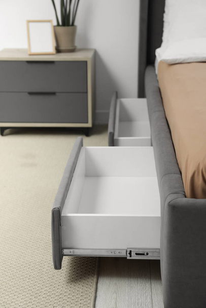 Storage drawers for bedding under modern bed in room - Fotoğraf, Görsel