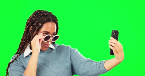 Selfie, γυαλιά ηλίου και στάση με μια γυναίκα σε ένα πράσινο φόντο οθόνη στο στούντιο για μια εικόνα προφίλ. Φωτογραφία, μόδα και στυλ με μια δροσερή νεαρή γυναίκα να ποζάρει για ενημέρωση της κατάστασης των μέσων κοινωνικής δικτύωσης. - Πλάνα, βίντεο