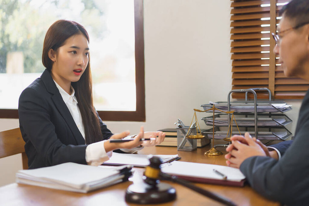 Recht en justitie concept, Jonge vrouwelijke advocaat uitleggen en consultancy contract met senior advocaat. - Foto, afbeelding