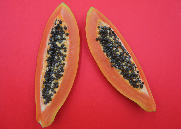 Red papaya slices against a colorful background - Photo, Image
