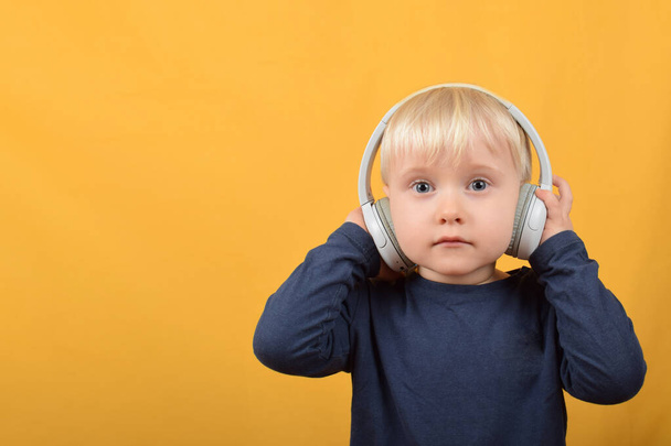 boy child listens to music in headphones - Fotó, kép