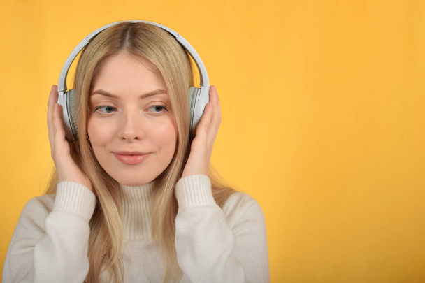 νεαρή όμορφη γυναίκα απολαμβάνοντας τη μουσική στα ακουστικά - Φωτογραφία, εικόνα