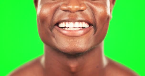 Zwarte man, tanden en glimlach met gebit op groen scherm, mondgezondheid met hygiëne en close-up van de mond op studio achtergrond. Schoonheid, gezondheidszorg en verzorging met gelukkig mannetje, gezicht en orthodontie. - Video