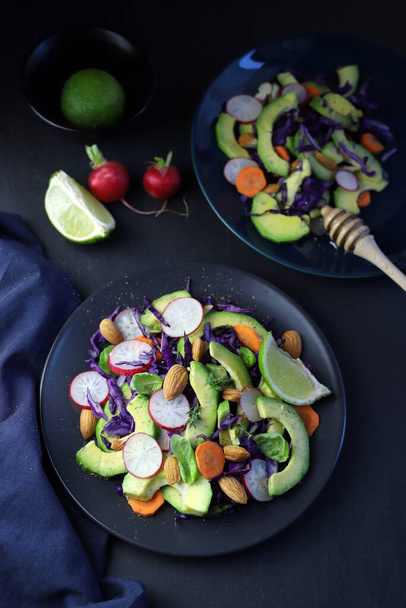 Fresh avocado and almond salad on dark background. Healthy food. Directly above. Copy space. - Φωτογραφία, εικόνα