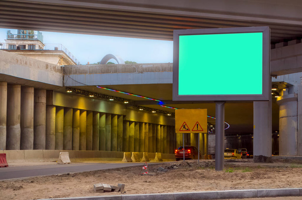 Billboard with a green background, Mock up. The scene under the concrete structure of the road bridge, the interchange in the city. - Photo, Image