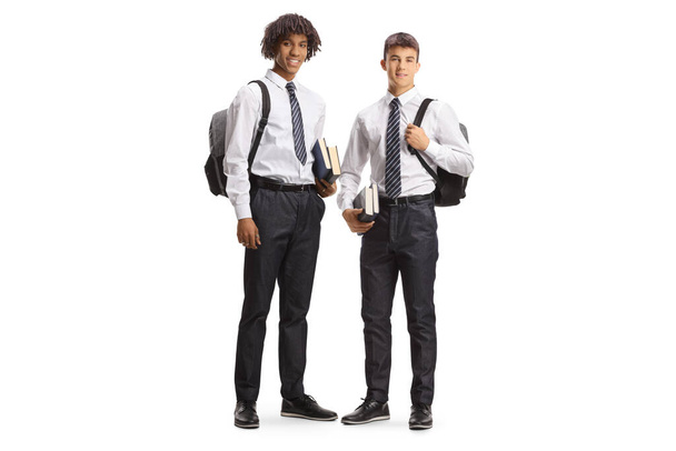 African american and caucasian male student in uniforms carrying backpacks and posing isolated on white background - Photo, Image