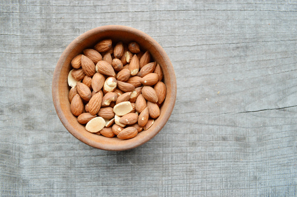 Almonds closeup on wooden background - Fotó, kép