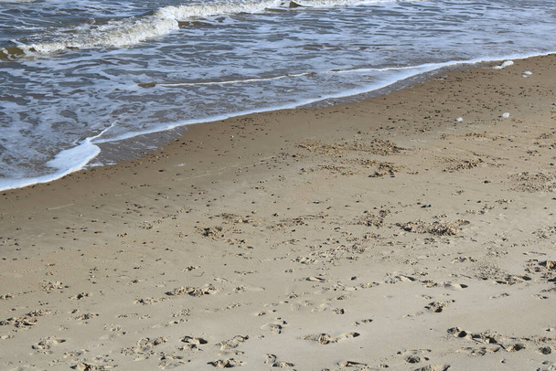 Παραλία σκηνή με άμμο σε πρώτο πλάνο και ήπια κύματα στο παρασκήνιο. Υψηλής ποιότητας φωτογραφία - Φωτογραφία, εικόνα
